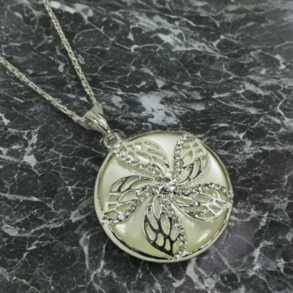 Flower round pendant with crystals set into it and on top of a white setting - Picture 4 of 7